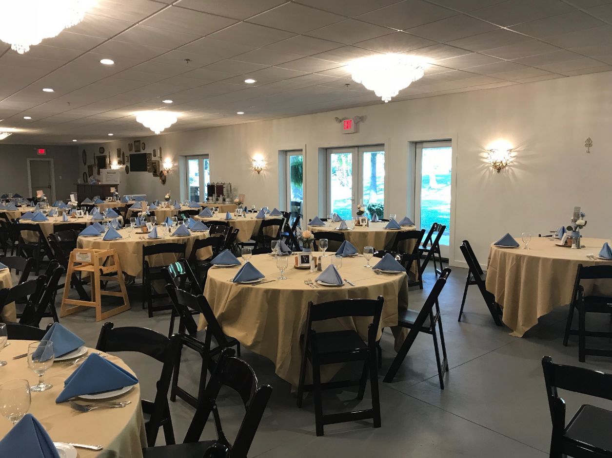 Stonegate Manor & Gardens Michigan wedding venue - wedding tables with tan tablecloths, blue folded napkins and black folding chairs