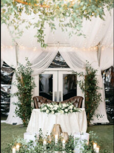 architectural florals and greenery for a wedding head table under an estate tent