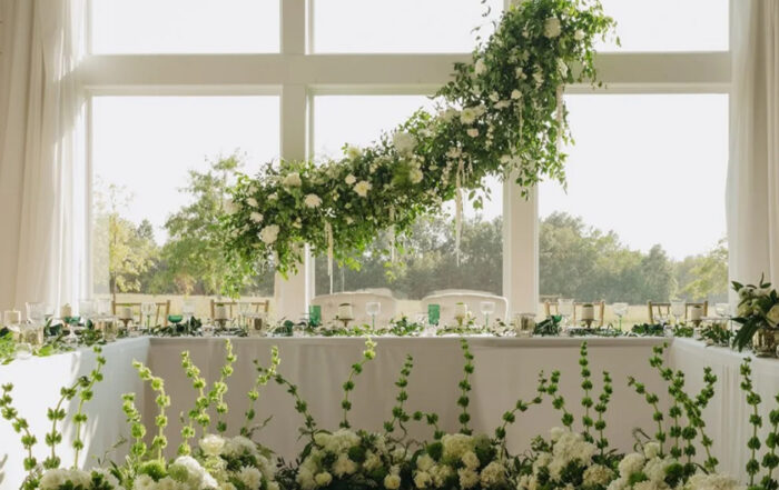 Architectural florals and greenery for a head table indoor wedding reception